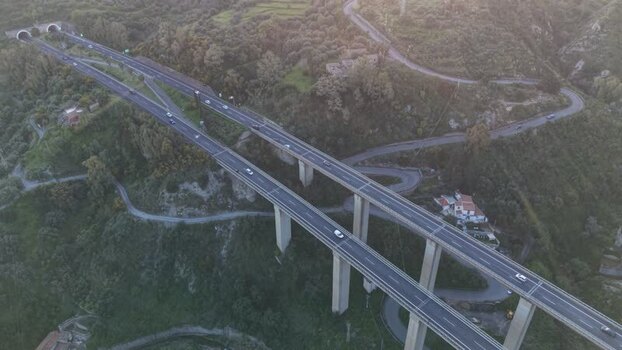 Aerial view of a highway viaduct spanning a lush valley Italy.