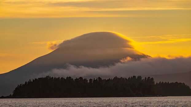 View of a cloud capped mountain and forested island United States.