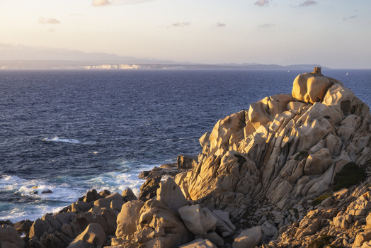 View of the weathered granite rock formations and the blue Mediterranean sea during golden hour at Capo Testa Sardegna Italy.