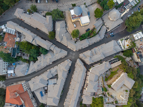 Aerial view of the historic Old Bazaar with its characteristic stone roofed buildings and narrow cobblestone streets in the heart of the city Gjirokaster Gjirokaster County Albania. Aerial view of the historic Old Bazaar with its characteristic stone roofed buildings and narrow cobblestone streets in the heart of the city Gjirokaster Gjirokaster County Albania.