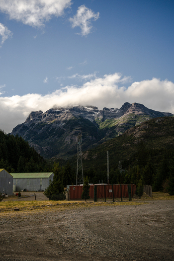 View of the Complejo hidroelectrico Futaleufu with industrial containers and power lines set against a backdrop of rugged mountains in Futaleufu Chubut Argentina. View of the Complejo hidroelectrico Futaleufu with industrial containers and power lines set against a backdrop of rugged mountains in Futaleufu Chubut Argentina.