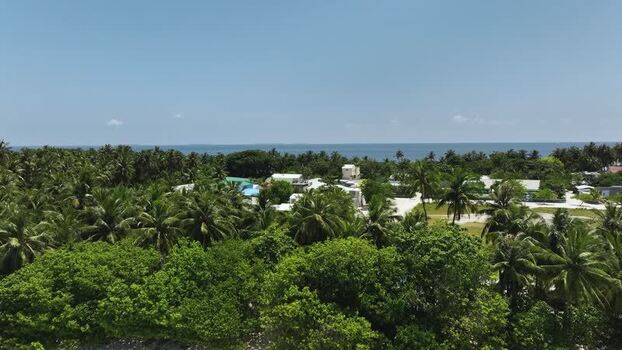 Aerial view of tropical island village and palm trees in Fulhadhoo Maldives. Aerial view of tropical island village and palm trees in Fulhadhoo Maldives.