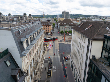 Aerial view of urban architecture a red bus crossing a street and distant hills under a cloudy sky in Biel Bienne Canton of Bern Switzerland. Aerial view of urban architecture a red bus crossing a street and distant hills under a cloudy sky in Biel Bienne Canton of Bern Switzerland.