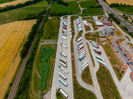 Aerial view of Serways Raststatte Hohenlohe Sud a busy highway rest area with parked semi trucks and trailers surrounded by agricultural fields in Neuenstein Baden Wurttemberg Germany. Aerial view of Serways Raststatte Hohenlohe Sud a busy highway rest area with parked semi trucks and trailers surrounded by agricultural fields in Neuenstein Baden Wurttemberg Germany.