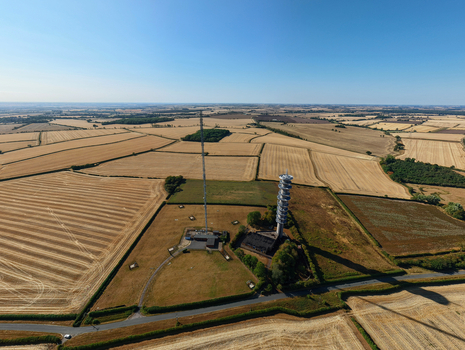Aerial view of the Morborne Hill Transmitter telecommunications tower surrounded by vast agricultural fields and rural landscape in Morborne England United Kingdom. Aerial view of the Morborne Hill Transmitter telecommunications tower surrounded by vast agricultural fields and rural landscape in Morborne England United Kingdom.