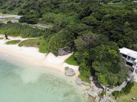 Aerial view of the coastline in the Hyakume area featuring a white sandy beach emerald green sea rocky outcrops and lush greenery in Nanjo Okinawa Japan. Aerial view of the coastline in the Hyakume area featuring a white sandy beach emerald green sea rocky outcrops and lush greenery in Nanjo Okinawa Japan.