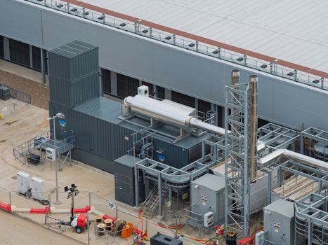 Aerial view of a data center facility featuring industrial power generators exhaust stacks and technical infrastructure in the United Kingdom.