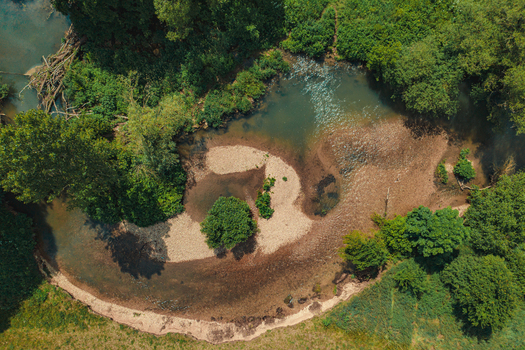 Aerial view of the Wasserwiesen river bend featuring gravel banks and lush green trees in Biberach an der Riss Baden Wurttemberg Germany.