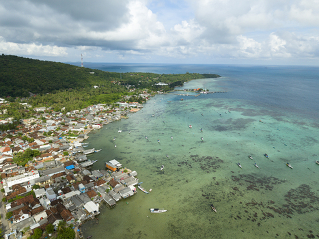 Aerial view of a vibrant coastal village where the turquoise waters meet the rustic rooftops creating a stunning contrast Karimunjawa Central Java Indonesia. Aerial view of a vibrant coastal village where the turquoise waters meet the rustic rooftops creating a stunning contrast Karimunjawa Central Java Indonesia.