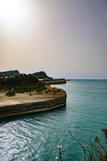Aerial view of the rugged coastline with turquoise waters and rocky cliffs in Corfu Ionian Islands Greece. Aerial view of the rugged coastline with turquoise waters and rocky cliffs in Corfu Ionian Islands Greece.