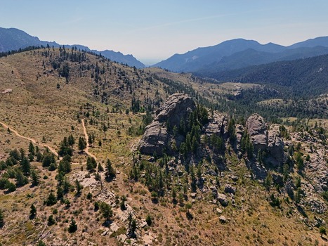 Aerial view of Walker Ranch featuring rugged rock formations pine trees and winding trails set against the mountainous landscape of Boulder Colorado United States.