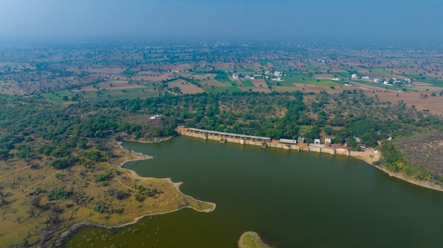 Aerial view of the reservoir and dam structure surrounded by lush greenery and agricultural fields near Jodhpur Rajasthan India. Aerial view of the reservoir and dam structure surrounded by lush greenery and agricultural fields near Jodhpur Rajasthan India.