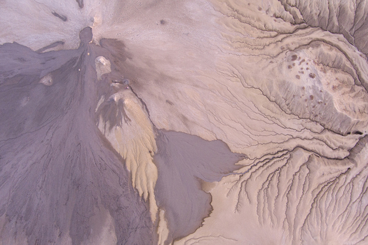 Aerial view of the mud volcanoes at Vulcanii Noroiosi Paclele Mari showing intricate patterns of dried mud flows and geological formations in Paclele Buzau County Romania.