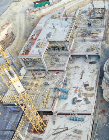 Aerial view of a large construction site featuring concrete foundations scaffolding and a yellow tower crane in Avcilar Istanbul Turkiye. Aerial view of a large construction site featuring concrete foundations scaffolding and a yellow tower crane in Avcilar Istanbul Turkiye.