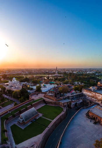 Aerial view of Lahore Fort with its historic walls courtyards and surrounding gardens at sunset in Lahore Punjab Pakistan.