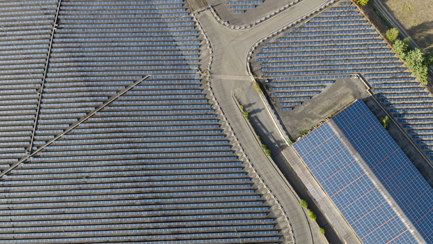 Aerial view of a large solar farm with rows of photovoltaic panels and a building with a solar roof in Ludwigshafen Rhineland Palatinate Germany. Aerial view of a large solar farm with rows of photovoltaic panels and a building with a solar roof in Ludwigshafen Rhineland Palatinate Germany.