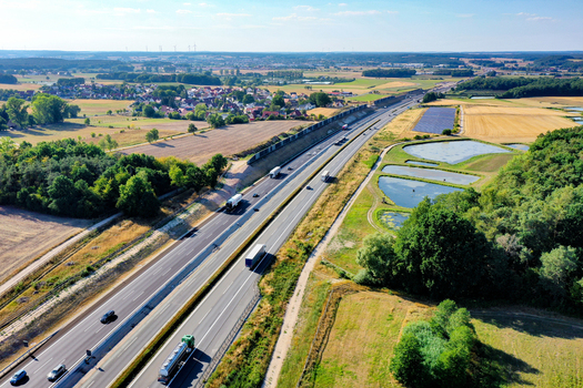 Nurnberg Germany 18 May 2024 Aerial view of the A73 highway with trucks and cars passing through the rural landscape of Bayern featuring green fields and small ponds. Nurnberg Germany 18 May 2024 Aerial view of the A73 highway with trucks and cars passing through the rural landscape of Bayern featuring green fields and small ponds.