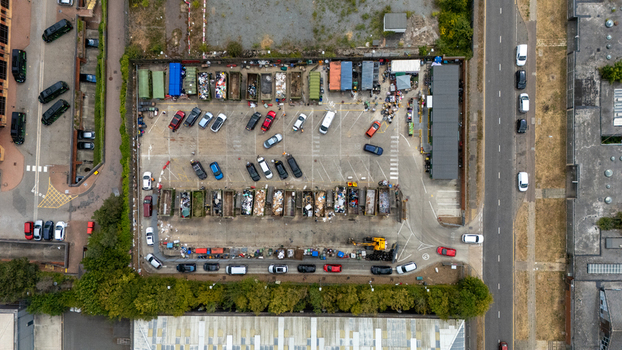 Aerial view of Stevenage Recycling Centre with various waste containers parked cars and industrial structures in Stevenage England United Kingdom.