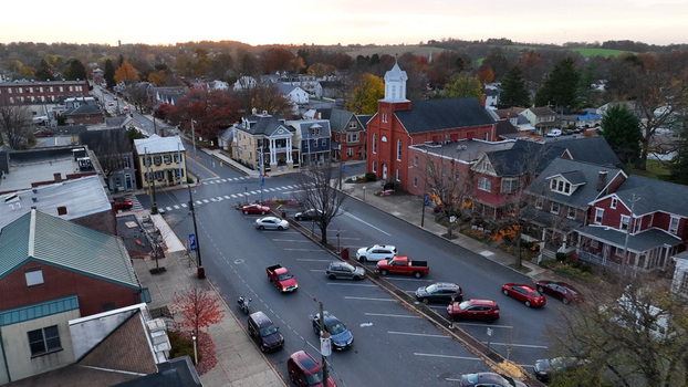 Aerial view of Manheim Square in autumn featuring historic brick buildings colorful fall foliage and cars parked along the streets in Manheim Pennsylvania United States.