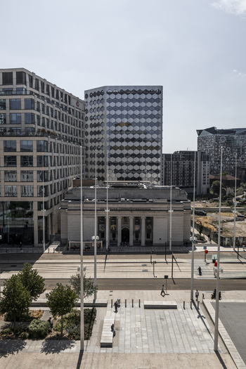 Aerial view of the Library of Birmingham with its honeycomb facade surrounded by modern office buildings tram tracks and a paved public square in Birmingham England United Kingdom.