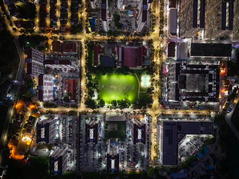 Aerial view of illuminated residential high rise buildings surrounding a central green park with bright street lighting at night in George Town Penang Malaysia. Aerial view of illuminated residential high rise buildings surrounding a central green park with bright street lighting at night in George Town Penang Malaysia.