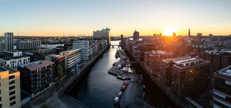 Aerial view of the HafenCity district featuring the Elbphilharmonie concert hall and modern buildings along the canal at sunset in Hamburg Hamburg Germany. Aerial view of the HafenCity district featuring the Elbphilharmonie concert hall and modern buildings along the canal at sunset in Hamburg Hamburg Germany.