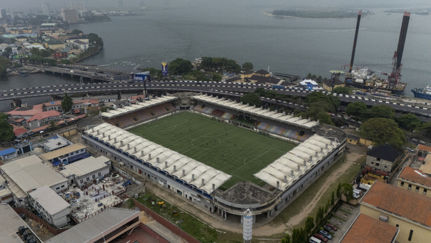 Aerial view of Mobolaji Johnson Arena with its green soccer pitch and stadium seating located near the waterfront and bridge in Lagos Lagos Nigeria. Aerial view of Mobolaji Johnson Arena with its green soccer pitch and stadium seating located near the waterfront and bridge in Lagos Lagos Nigeria.