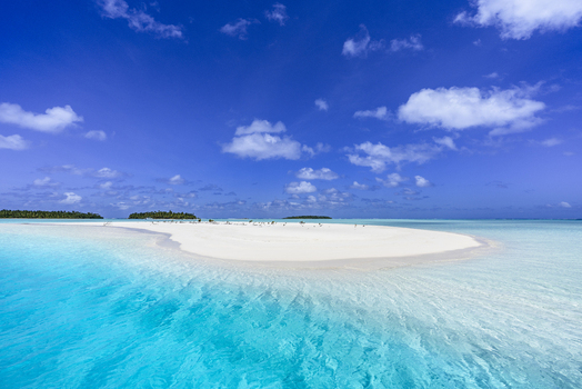View of One Foot Island with white sand beach and turquoise lagoon water in Arutanga Cook Islands. View of One Foot Island with white sand beach and turquoise lagoon water in Arutanga Cook Islands.