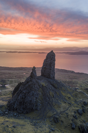 Aerial view of The Storr rock formation with dramatic pinnacles and vibrant pink sunrise clouds over the sea in Isle of Skye Scotland United Kingdom. Aerial view of The Storr rock formation with dramatic pinnacles and vibrant pink sunrise clouds over the sea in Isle of Skye Scotland United Kingdom.