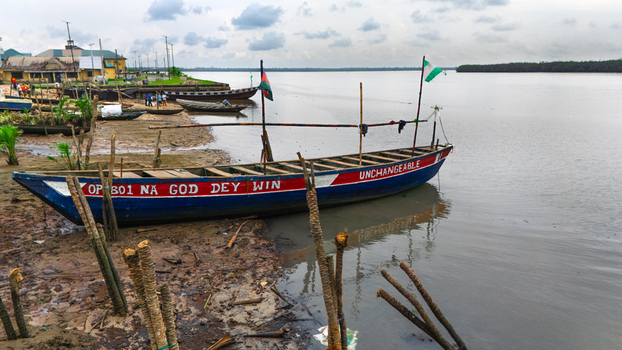 Aerial view of wooden boats moored along the muddy riverbank in Rivers Nigeria.