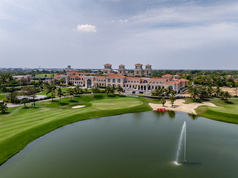 Ahmedabad Gujarat India 21 March 2026 Aerial view of Kalhaar Blues Greens Golf Club featuring lush fairways a water hazard with a fountain and the clubhouse under a clear sky.