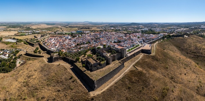 Aerial view of the historic star shaped fortifications and old town of Elvas featuring stone walls white buildings and surrounding dry landscape in Elvas Portalegre Portugal. Aerial view of the historic star shaped fortifications and old town of Elvas featuring stone walls white buildings and surrounding dry landscape in Elvas Portalegre Portugal.