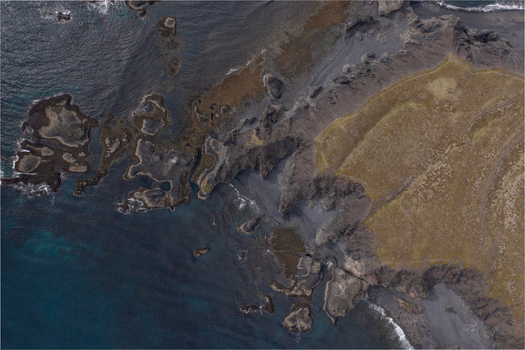 Aerial view of the dramatic black sand beach and rugged rock formations of Djupalonssandur along the coastline of Iceland. Aerial view of the dramatic black sand beach and rugged rock formations of Djupalonssandur along the coastline of Iceland.