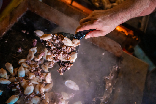 View of the succulent squid sizzling on a hot plate smoke swirling as a spatula lifts the delectable seafood a culinary dance of flavors Pula Istria County Croatia.