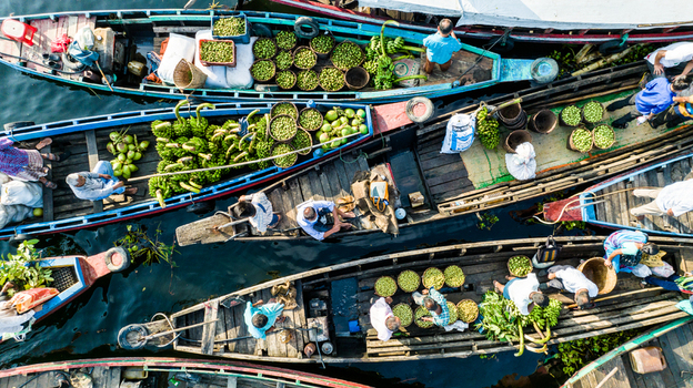 Rangamati Bangladesh 19 October 2022 Aerial view of boats laden with fresh bananas and green vegetables on the water with local farmers and traders working on board.