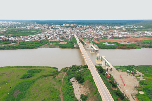 Aerial view of the Buipe Bridge spanning the Black Volta River with the town of Buipe in the background surrounded by lush green vegetation in Buipe Savannah Region Ghana. Aerial view of the Buipe Bridge spanning the Black Volta River with the town of Buipe in the background surrounded by lush green vegetation in Buipe Savannah Region Ghana.