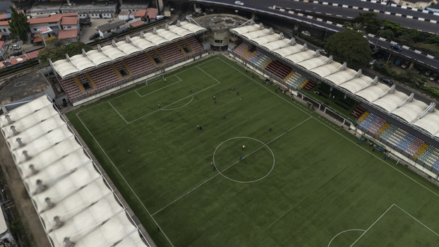 Aerial view of Mobolaji Johnson Arena on Lagos Island featuring the green football pitch spectator stands with white canopy roofs and urban infrastructure in Lagos Lagos Nigeria. Aerial view of Mobolaji Johnson Arena on Lagos Island featuring the green football pitch spectator stands with white canopy roofs and urban infrastructure in Lagos Lagos Nigeria.