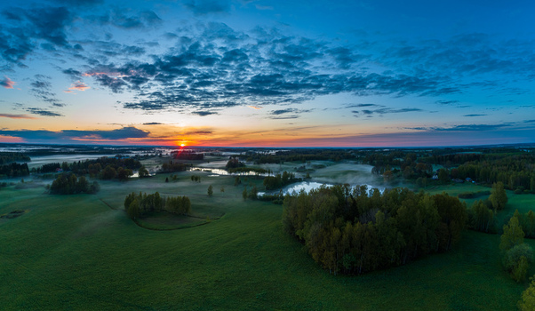 Aerial view of a misty rural landscape with small ponds and trees at sunrise in Latvia. Aerial view of a misty rural landscape with small ponds and trees at sunrise in Latvia.