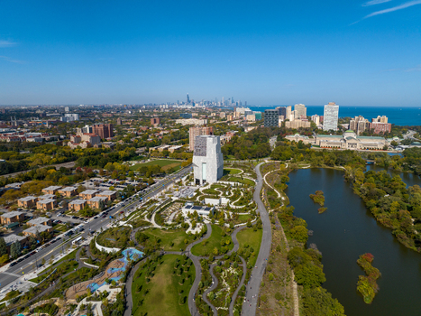 Aerial view of The Obama Presidential Center surrounded by parkland winding paths and a lake with the Chicago skyline in the distance in Chicago Illinois United States. Aerial view of The Obama Presidential Center surrounded by parkland winding paths and a lake with the Chicago skyline in the distance in Chicago Illinois United States.