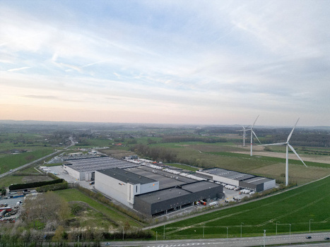 Aerial view of industrial buildings casting long shadows in the fading light windmills standing tall against the horizon Ath Wallonia Belgium. Aerial view of industrial buildings casting long shadows in the fading light windmills standing tall against the horizon Ath Wallonia Belgium.