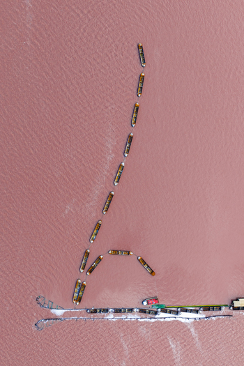 Aerial view of boats lined up across the pink toned water near the salt flats creating a striking contrast between the vessels and the vibrant water San Pedro del Pinatar Region of Murcia Spain. Aerial view of boats lined up across the pink toned water near the salt flats creating a striking contrast between the vessels and the vibrant water San Pedro del Pinatar Region of Murcia Spain.