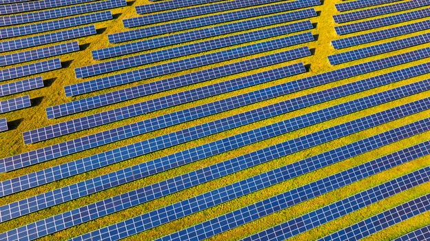 Aerial view of a large solar farm with rows of photovoltaic panels installed on green grass in the countryside of Dorset England United Kingdom. Aerial view of a large solar farm with rows of photovoltaic panels installed on green grass in the countryside of Dorset England United Kingdom.