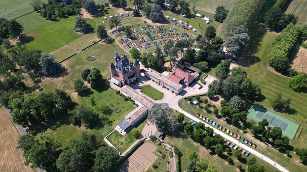 Francheleins France 04 June 2023 Aerial view of Chateau de Vataneins with its historic turrets surrounded by a large park filled with vintage cars during an event. Francheleins France 04 June 2023 Aerial view of Chateau de Vataneins with its historic turrets surrounded by a large park filled with vintage cars during an event.