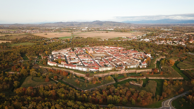 Aerial view of the Vauban walled city of Neuf Brisach with star shaped fortifications historic buildings and surrounding autumn forest in Neuf Brisach Grand Est France. Aerial view of the Vauban walled city of Neuf Brisach with star shaped fortifications historic buildings and surrounding autumn forest in Neuf Brisach Grand Est France.