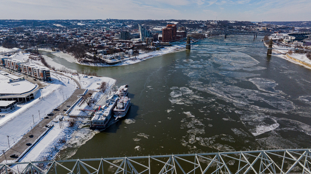 Aerial view of the frozen Ohio River with ice floes snow covered banks and the city skyline under a clear winter sky in Cincinnati Ohio United States. Aerial view of the frozen Ohio River with ice floes snow covered banks and the city skyline under a clear winter sky in Cincinnati Ohio United States.