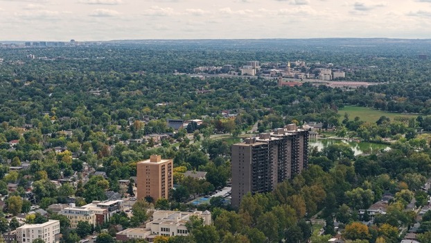 Aerial view of the Cherry Creek area featuring high rise apartment buildings surrounded by lush green trees and residential neighborhoods in Denver Colorado United States. Aerial view of the Cherry Creek area featuring high rise apartment buildings surrounded by lush green trees and residential neighborhoods in Denver Colorado United States.