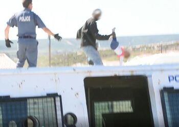 Heart stopping moment South African dad throws his own toddler off roof in protest at illegal shack being demolished Heart stopping moment South African dad throws his own toddler off roof in protest at illegal shack being demolished