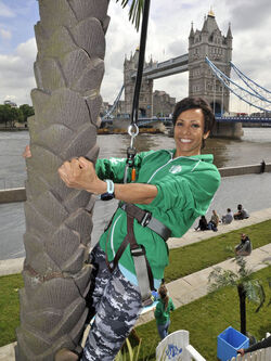 Dame Kelly Holmes climbs up a 23ft coconut tree at the Vita Coco Coconut Grove in Potters Fields London