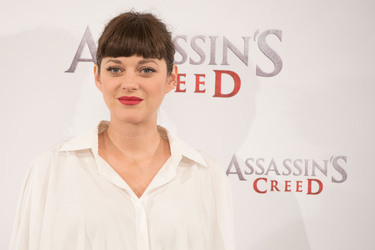 Pregnant Marion Cotillard covers her bump in a loose white Area shirt as she poses with Michael Fassbender at the Assasin s Creed Photocall Madrid