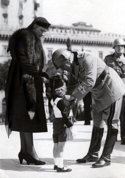 Benito Mussolini Duce dell Italia fascista durante la celebrazione del IV Annuale della fondazione dell Impero consegna ai figli dei caduti le decorazioni al Valor Militare concesse per le campagne d Africa Spagna e Albania